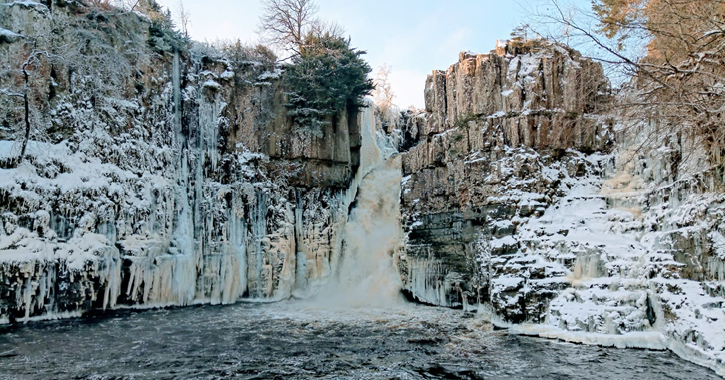 View of High Force Waterfall covered in snow